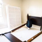 a person disassembling a bed