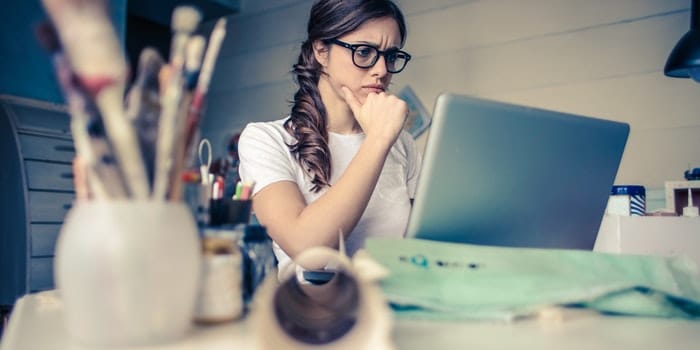 A girl reading online how to spot a moving scam