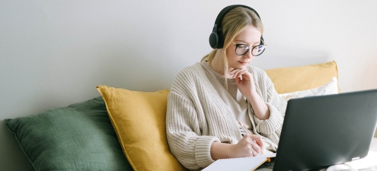 a woman with headphones working on a laptop