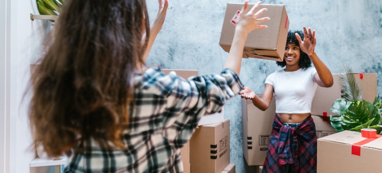 tow girls packing after choosing between hiring movers vs moving by yourself