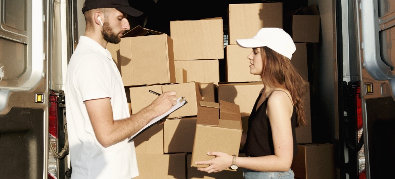 one of the movers Santa Ana has doing inventory of the boxes with a girl 