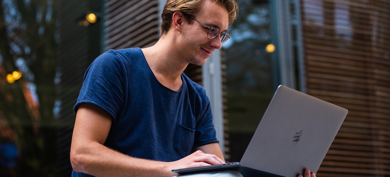 Young man using a laptop to research moving from Yorba Linda to Costa Mesa