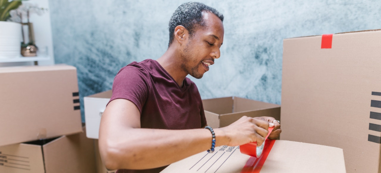 a man taping a moving box