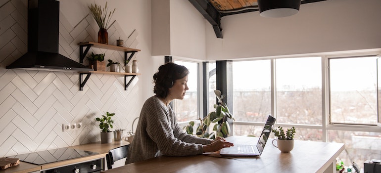 Young woman using a laptop to plan moving from Garden Grove to Newport Beach