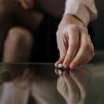 A woman placing her wedding ring on the table