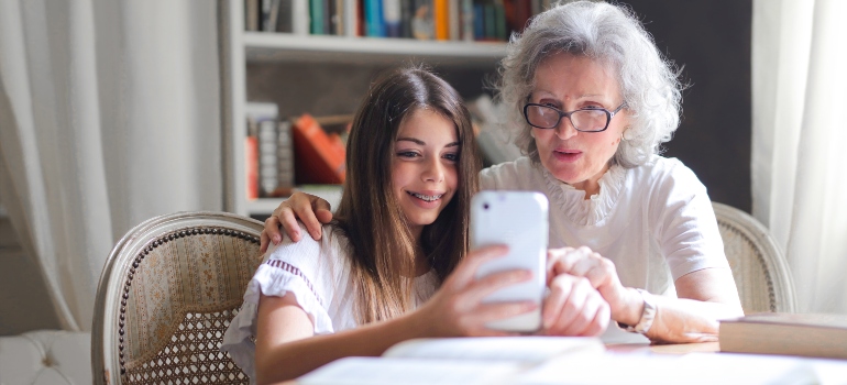 Granddaughter and grandmother looking at a phone