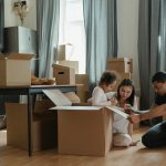 A family sitting in a pile of moving boxes