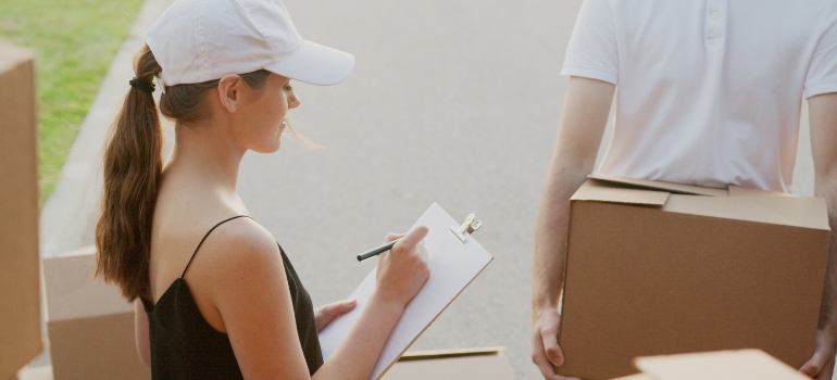 A woman writing down a checklist to organize a relocation from Lake Forest to Long Beach