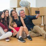 a family taking a picture in front of moving boxes