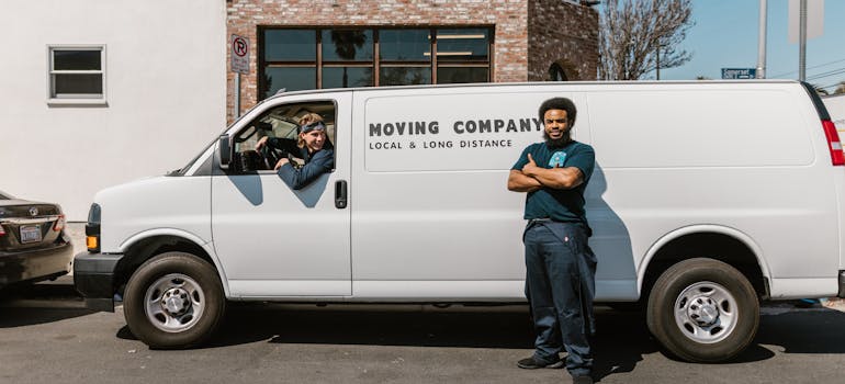 two people and a white moving company van